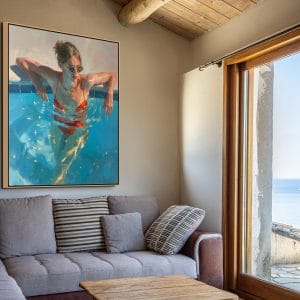 Malba na zdi ženy v bazénu s tyrkysovou vodou a červenými plavkami.